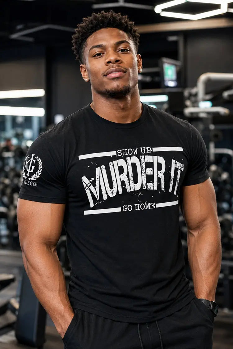 Man wearing a black t-shirt with text in a gym setting